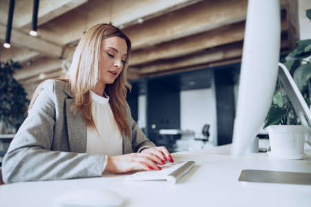 Portrait of a young smart businesswoman sitting at her working table in officeの写真素材