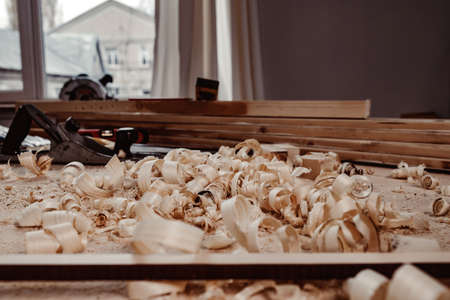 Working table with wood shavings in carpentry workshop