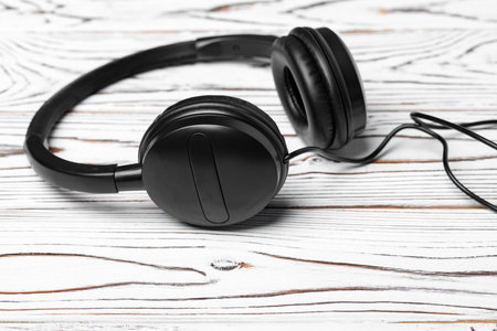 Black headphones with wire on wooden backgroundの写真素材