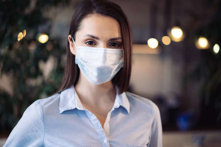 Potrait of a young beautiful businesswoman wearing medical face mask