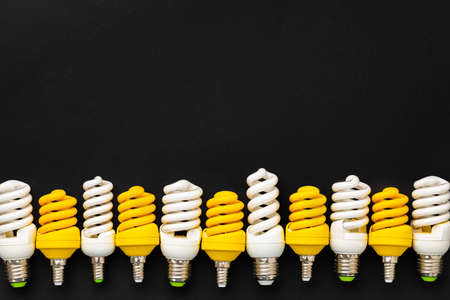 White and yellow light bulbs on black background