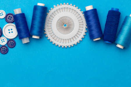Thread spools and buttons on blue abckgroundの写真素材