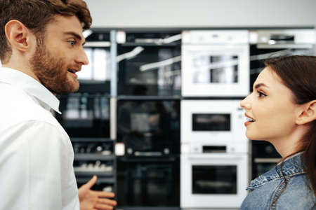 Young couple choosing new electric oven in hypermarketの写真素材