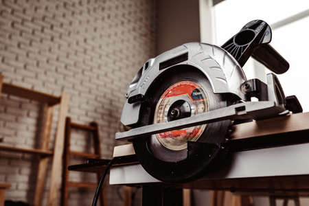 Electrical wheel saw on working table in carpentry workshop
