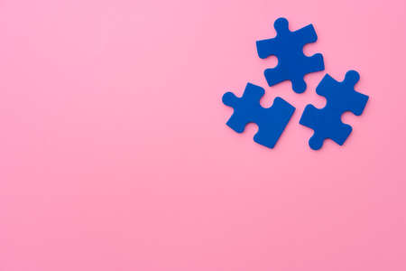 Blue puzzle pieces on paper background top view photo