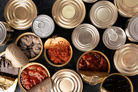 Many cans with conserved fish on wooden tableの写真素材