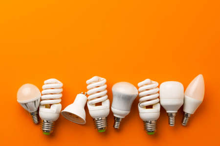 Many light bulbs on bright orange backgroundの写真素材
