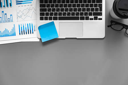 Printed graphs and laptop on dark gray surfaceの写真素材