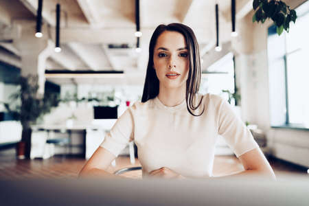 Close up portrait of a young woman working in office at the table