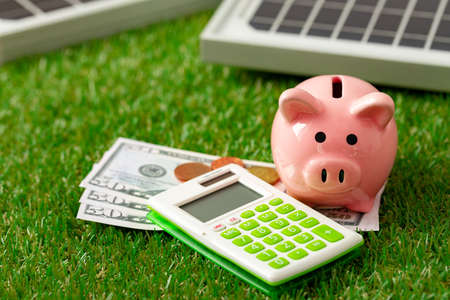Solar panel model and piggy bank close up