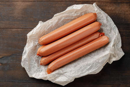 Fresh meat sausages on brown wooden table