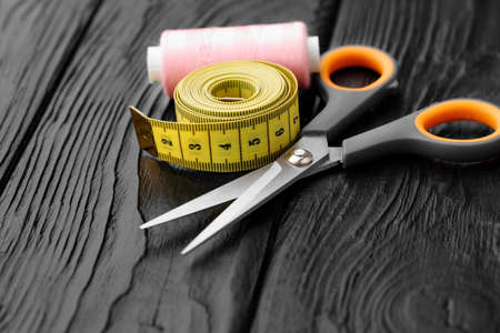 Colorful sewing utensils on black wooden surfaceの写真素材