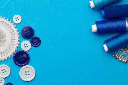Thread spools and buttons on blue abckground