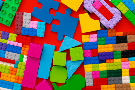Plastic constructor details on red background close up