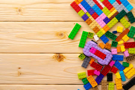 Toy constructor details on wooden background close up