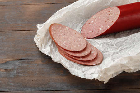 Chopped meat sausage on wooden board close upの写真素材
