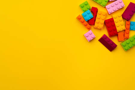 Kids toy constructor details scattered on yellow backgroundの写真素材