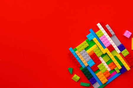 Plastic constructor details on red background close up