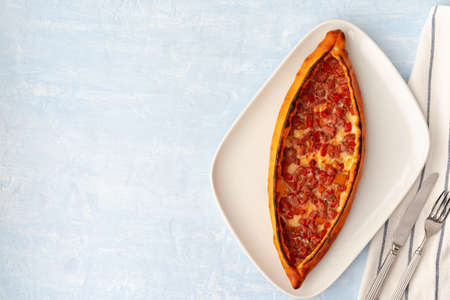 Turkish baked Pide bread on light blue wooden surfaceの写真素材