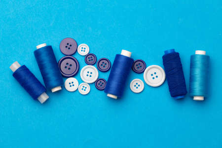 Thread spools and buttons on blue abckgroundの写真素材