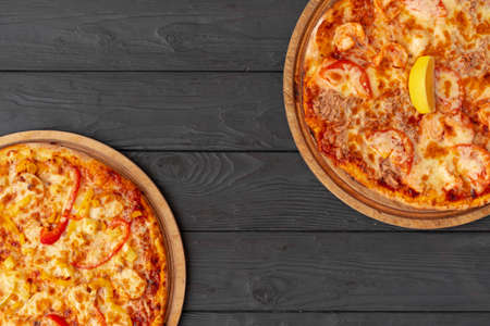 Tasty pizza on black wooden background top viewの写真素材
