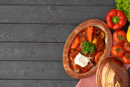 Steamed meat with vegetables in tomato sauce on wooden backgroundの写真素材