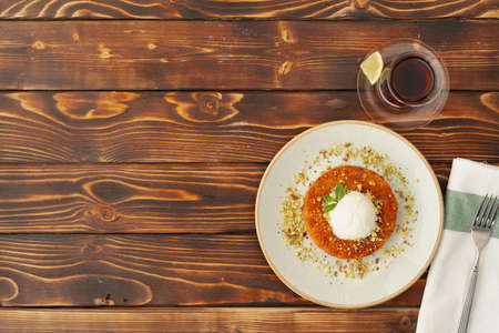 Turkish dessert kunefe with ice cream ball on wooden backgroundの写真素材