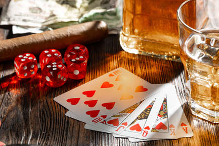 Playing poker with whiskey and cigars on tableの写真素材