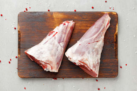 Raw lamb shanks on wooden board close upの写真素材