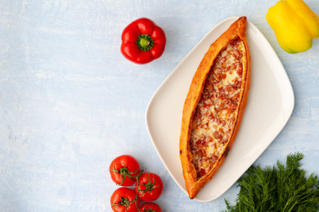 Turkish baked Pide bread on light blue wooden surfaceの写真素材