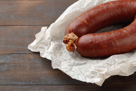 Fresh meat sausages on brown wooden tableの写真素材