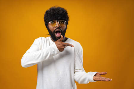 Young african american man cheerfully showing copy spaceの写真素材