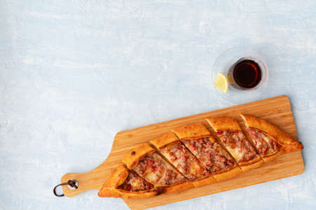 Turkish baked Pide bread on light blue wooden surface