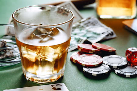 Cuban cigar, whiskey glass and chips on table