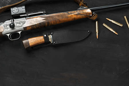 Hunting rifle and cartridges on dark wooden backgroundの写真素材