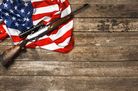 Automatic rifle on USA flag on wooden backgroundの写真素材