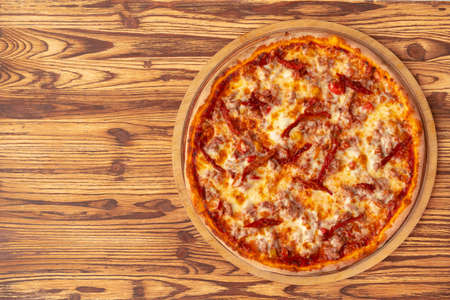 Top view of freshly baked pizza on wooden backgroundの写真素材