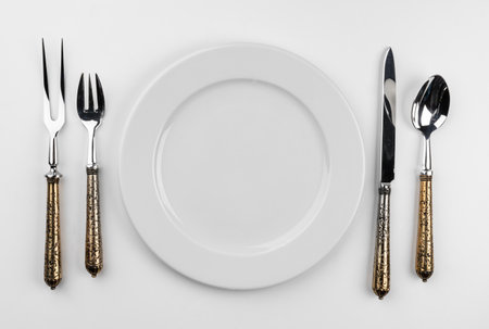 Empty plate with cutlery isolated on white backgroundの写真素材