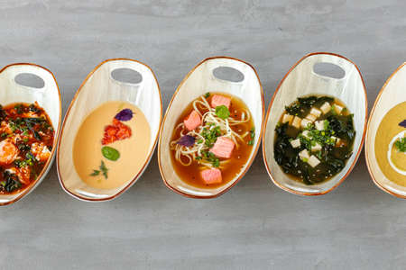 Tom Yam, Miso soup and cream soups on gray tableの写真素材