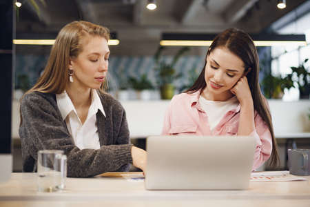 Two young women working together in officeの写真素材