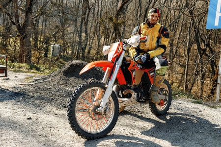 KRASNODAR, RUSSIA - OCTOBER 2020: Male driver sitting on motorcross bike on road in forestのeditorial素材