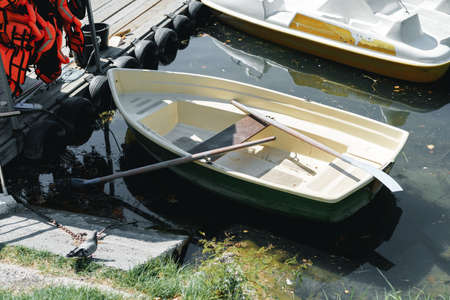 Small boat tied to a wooden pier on the lakeの写真素材