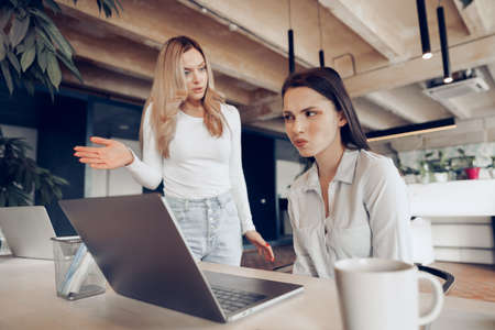 Young female boss scolding her female subordinate for bad work resultsの写真素材