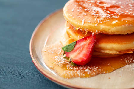 Pancakes with strawberry and maple syrup on tableの写真素材