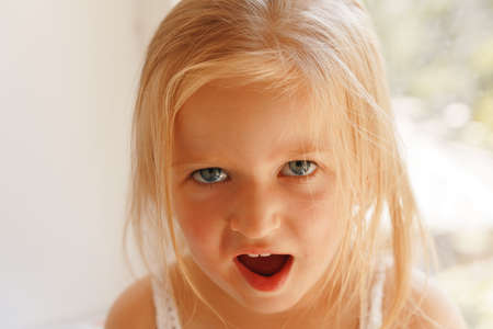 Close up portrait of a little blonde girl on a summer dayの写真素材
