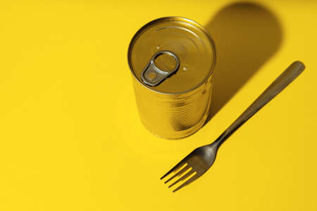 Canned food tin on yellow studio backgroundの写真素材