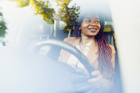 Portrait of positive african american lady inside the car