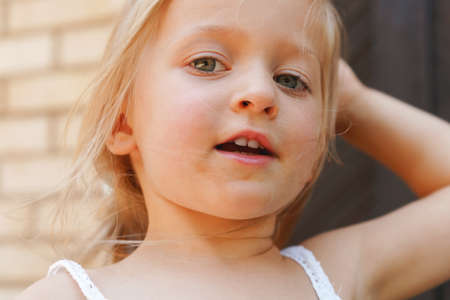 Close up portrait of a little blonde girl on a summer dayの写真素材