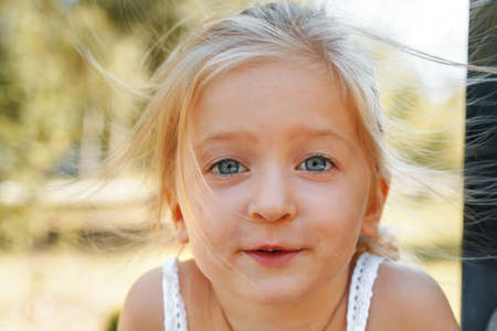 Close up portrait of a little blonde girl on a summer dayの写真素材
