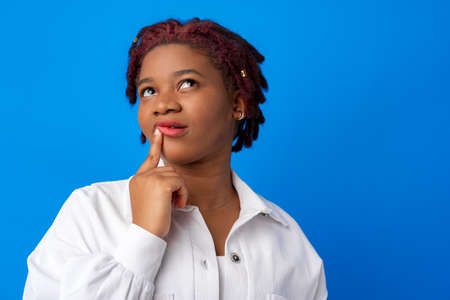 Thoughtful young african american female portrait against blue background